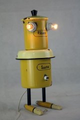 Personnage en émail jaune, assemblage de pots de pâtes et sucre, gamelle, tube et manches.