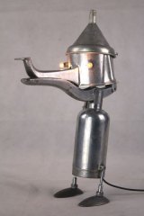 Personnage par assemblage en aluminium avec élément de cireuse, pressoir, entonnoir et cuillères. Sculpture lumineuse.