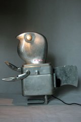 Sculpture homme oiseau aluminium assemblage d'éléments de trancheuse familiale en fonte d'aluminium, une boite gamelle "MA.MOU.Marseille 1939", pince en forme de crabe et 2 clenches aux pieds.