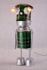Personnage thermos écossais vert détourné, assemblage avec écumoire, moules, tube, couvercle et manches de cuillères. Sculpture lumineuse.