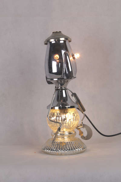 Année de création: 2024. Dimensions: 27x 11 x 13 cm. Poids: 0.7 kg. Matières: métal, chromé, inox, bakélite, verre. Composition: coupe de sport, pot à lait, bougeoir, pince à escargot. Alimentation: 12 V 2 E10 . Pièce unique.